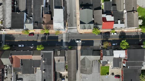 Aerial-top-down-shot-of-driving-cars-on-main-street-of-small-town-in-USA