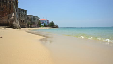 Waves-Lapping-Shore-on-Sandy-Beach,-Close-Up-of-Exotic-Idyllic-Picture-Perfect-Beaches-in-Zanzibar-in-Africa-with-Beautiful-Turquoise-Blue-Crystal-Clear-Sea-Water-with-Blue-Sky-on-a-Sunny-Day