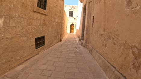 Fast-moving-along-the-tiny-and-cozy-streets-of-Malta,-showcasing-the-historical-charm-of-Mediterranean-architecture