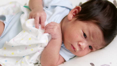 Close-up-shot-of-a-baby-who-is-cooing-and-stretching-as-she-responds-to-those-who-are-surrounding-her