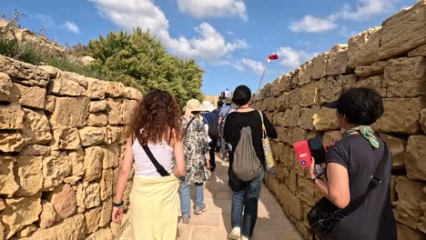 Travelers-and-explorers-walking-along-the-walls-of-the-historic-Citadel-in-Gozo,-Malta