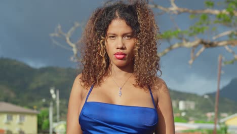 A-young-curly-haired-girl-in-a-short-blue-dress-is-enjoying-a-tropical-park-in-Trinidad