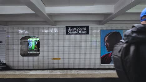 Video-Einer-U-Bahn-Station-In-Paris---Leute-Laufen-Auf-Dem-Bahnsteig,-Während-Sie-Auf-Die-U-Bahn-Warten---Station-Straßburg-Saint-Denis,-Paris---Frankreich