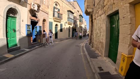 Strolling-down-a-quaint-street-in-Malta-during-daylight,-surrounded-by-charming-architecture-in-a-pedestrian-area