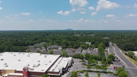 Aerial-lateral-shot-of-american-suburb-neighborhood-beside-large-shopping-center-in-USA