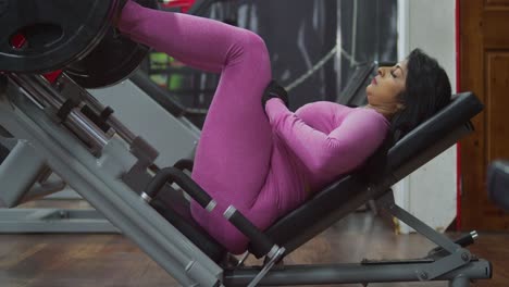 A-woman-is-doing-exercises-at-the-gym,-dressed-in-workout-gear