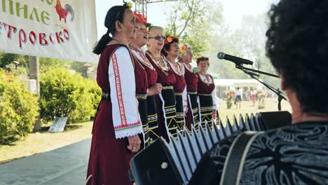 Ladies-Bulgarian-folk-choir-sing-accompanied-by-accordian-village-festival