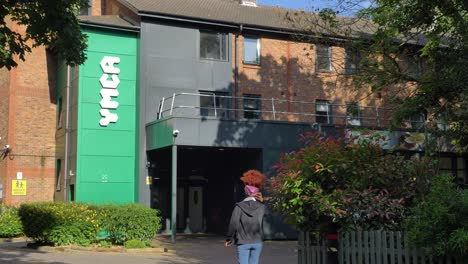 Young-black-woman-walks-into-YMCA-in-Ealing-London-United-Kingdom-June-2024