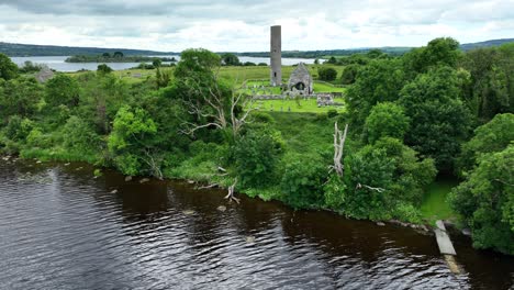 Ireland-Epic-locations-drone-flying-to-island-to-historic-church-and-round-tower-on-holy-Island-Lough-Derg-in-the-middle-of-The-Shannon-River