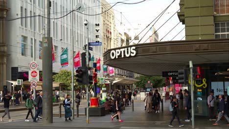 Menschen-Schlendern-Durch-Die-Geschäftige-Bourke-Street-Mall,-Ein-Einkaufs--Und-Geschäftsviertel-In-Der-Innenstadt-Von-Melbourne,-Mit-Einem-Optus-Geschäft-An-Der-Ecke-Bourke-Street-Und-Elizabeth-Street