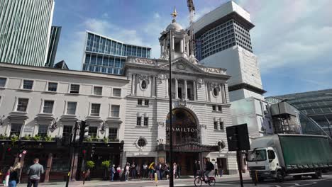 Victoria-Palace-Theatre-In-London-Mit-Menschen,-Die-Sich-An-Einem-Sonnigen-Tag-Draußen-Versammelt-Haben