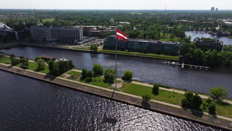 Cinematic-Establishing-Drone-Shot-Above-Latvian-Flag-Waving-in-the-Wind-on-Beautiful-Summer-Day