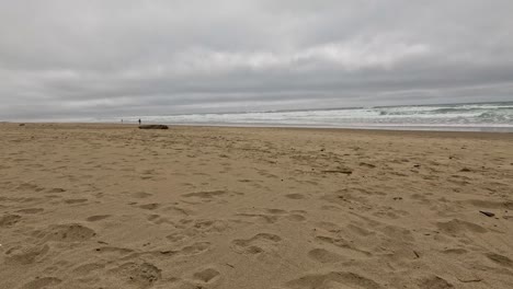 La-Gente-Camina-Por-La-Playa-En-Un-Día-Sombrío