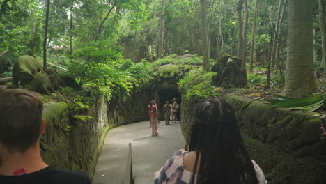 A-group-of-tourists-take-pictures-with-phones-at-Monkey-Forest-Ubud-Bali,-Indonesia---dolly-left