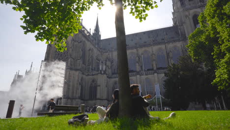 Pareja-Sentada-Junto-Al-árbol-Con-La-Iglesia-Catedral-De-Linz-Al-Fondo-En-Austria