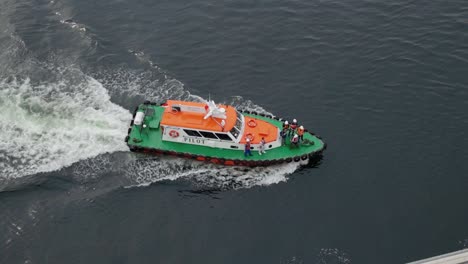 Aerial-View-Of-Coast-Guard-Patrol-Boat-Cruising-In-High-Speed-Approaching-A-Foreign-Ship-For-Escort