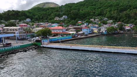 Toma-De-órbita-Aérea-Ascendente-Del-Puerto-Con-Embarcadero-En-La-Ciudad-De-Soufriere,-Santa-Lucía