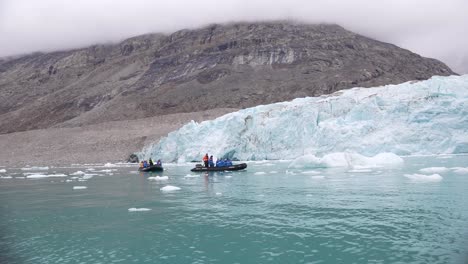 Turistas-En-Barcos-Bajo-El-Glaciar-En-La-Costa-Del-Parque-Nacional-Noreste-De-Groenlandia,-Cámara-Lenta