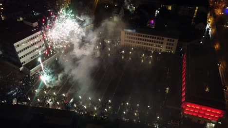 Menschenmenge-Auf-Dem-Stadtplatz-Feiert-Neujahr-Mit-Feuerwerk,-Drohnenansicht