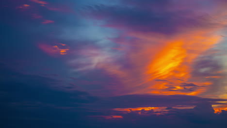 Ein-Lebendiger-Sonnenuntergangshimmel-Wechselt-Von-Orangefarbenen-Zu-Violetten-Farbtönen-über-Einem-Ruhigen-Horizont