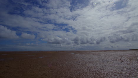 Panning-shot-of-the-beach-at-low-tide,-at-Theddlethorpe,-Dunes,-National-Nature-Reserve-at-Saltfleetby