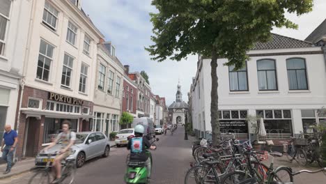 Street-Scene-Of-People-Biking-On-Zijlpoort-City-Gate-In-Leiden,-The-Netherlands