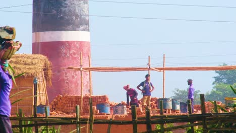 Workers-busy-at-a-South-Asian-brick-field,-shaping-and-drying-clay-bricks-under-the-sun