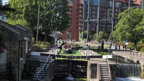 Casa-Flotante-Entrando-En-St-Pancras-Lock,-Una-Pintoresca-Vía-Fluvial-Y-Esclusa-Del-Siglo-XIX,-King&#39;s-Cross,-Londres,-Reino-Unido,-Julio-De-2023