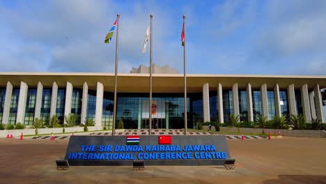 Sir-DK-Jawara-international-conference-entrance-centre-facade-with-Gambia-flags-waving-wide-static-view