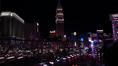 Tráfico-Nocturno-Intenso-En-El-Strip-De-Las-Vegas,-Nevada,-EE.UU.,-Edificios-Del-Hotel-Casino-Veneciano-Y-Torre-De-Luces