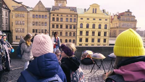 Tourists-on-Prague-Charles-bridge-enjoying-the-local-street-musicians-and-artists