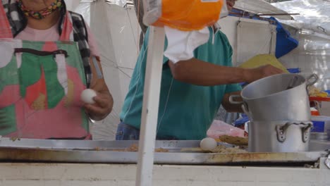 Street-Food-cooking-woman-in-Mexico-City,-egg-fry-on-hot-plate,-tortilla