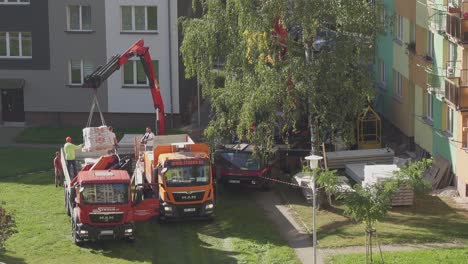 MAN-Trucks-of-Czech-Straub-construction-company,-crane-transporting-pile-of-blocks-from-a-flatbed-lorry