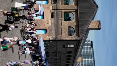 Bustling-outdoor-market-at-Coal-Drops-Yard,-Kings-Cross-on-a-sunny-day,-vertical-shot