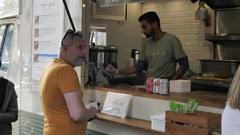 Food-vendor-selling-street-food-in-Canopy-Market,-King's-Cross,-London,-UK,-July-2023