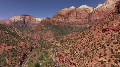 Majestuosa-Vista-De-Los-Sinuosos-Caminos-Del-Parque-Nacional-Zion-Y-Los-Imponentes-Acantilados-Rojos-Bajo-Un-Cielo-Despejado