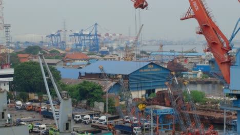 Grúas-Portuarias-Rojas-Y-Barcazas-En-El-Puerto-De-Tanjung-Priok