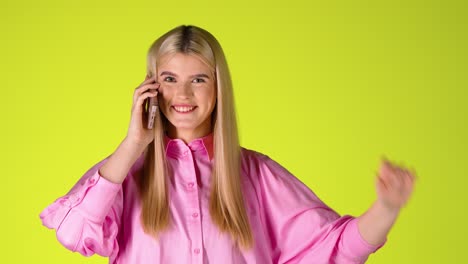 Pretty-Blonde-Woman-Talking-On-Phone-Smiling-and-In-Good-Mood,-Colorful-Studio-Shot