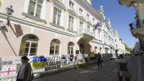 War-in-Ukraine-protest-outside-Russian-embassy-with-signs-draped-along-fence-by-cobblestone-road