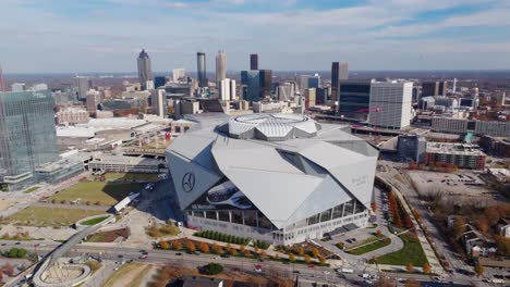 Aerial-of-Mercedes-Benz-Stadium-surrounded-by-Downtown-Atlanta-modern-commercial-skyline-and-skyscrapers-buildings-in-afternoon