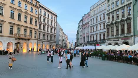 Crowd-of-tourists-at-Main-Square-of-Old-Town-of-Krakow-in-the-evening,-renaissance-buildings-and-picturesque-streets-of-Poland