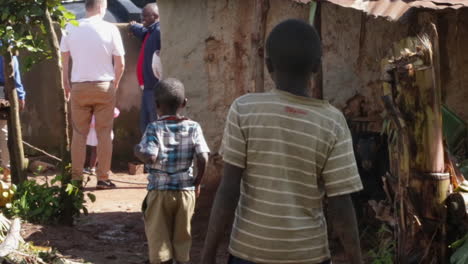 Niños-Negros-En-Una-Remota-Aldea-Rural-Siguiendo-A-Un-Hombre-Blanco-Caucásico-Fuera-De-Su-Casa