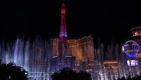 Bellagio-Music-Fountain-on-Las-Vegas-Strip-at-Night,-Paris-Casino-Hotel,-Eiffel-Tower-and-Buildings-in-Lights