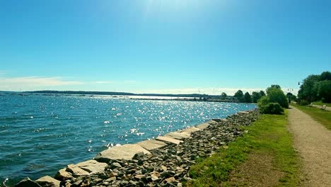 Walking-trail-along-Casco-Bay-in-Portland,-Maine-with-boats-moored-in-the-distance