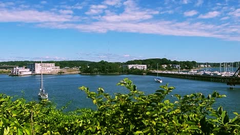 Sail-boat-moored-in-bay-in-front-of-old-food-factory-in-Portland,-Maine