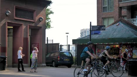 Cyclists-ride-past-the-entrance-of-the-historic-Thames-Tunnel-designed-by-Marc-Isambard-Brunel-in-Isle-of-Dogs,-London,-UK,-July-2023