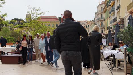 People-walking-through-bustling-streets-of-Cannes,-France-on-cloudy-day