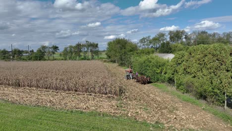 Time-honored-harvest-methods,-with-horses,-in-a-tranquil-rural-landscape-as-autumn-colors-emerge