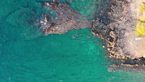 Aerial-straight-down-view-of-submerged-rocks-in-clear-turquoise-water-off-the-coast-of-Hawaii