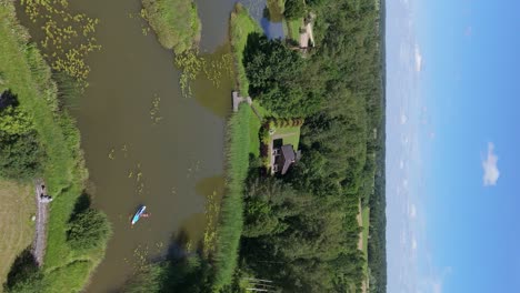 Fliegen-über-Junge-Frau-Stand-Up-Paddeln-Auf-SUP-Board-Auf-Teich-Im-Sommer